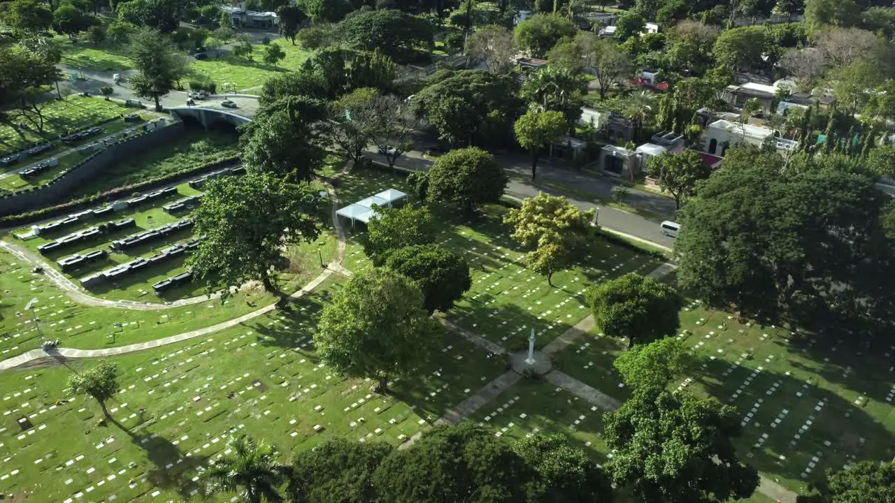 Drone shot of Memorial cemetery with trees and cars in the Philippines