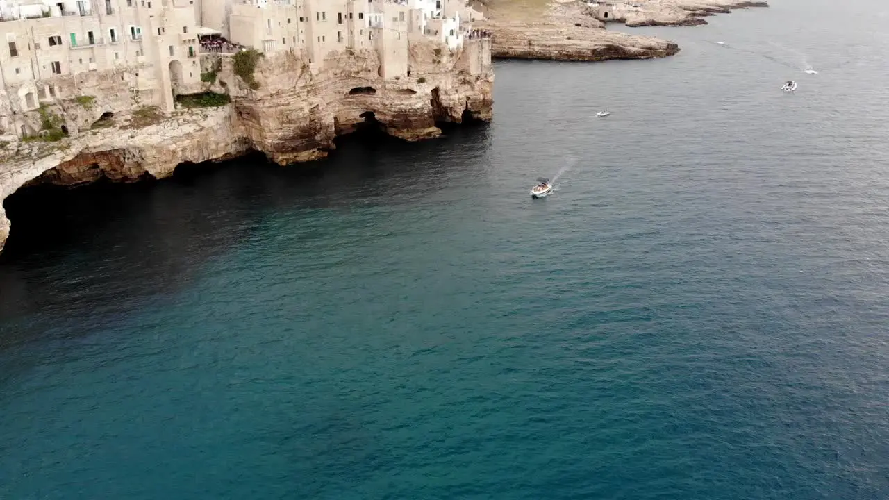 Drone reveals Polignano cliff with a vertical pan movement