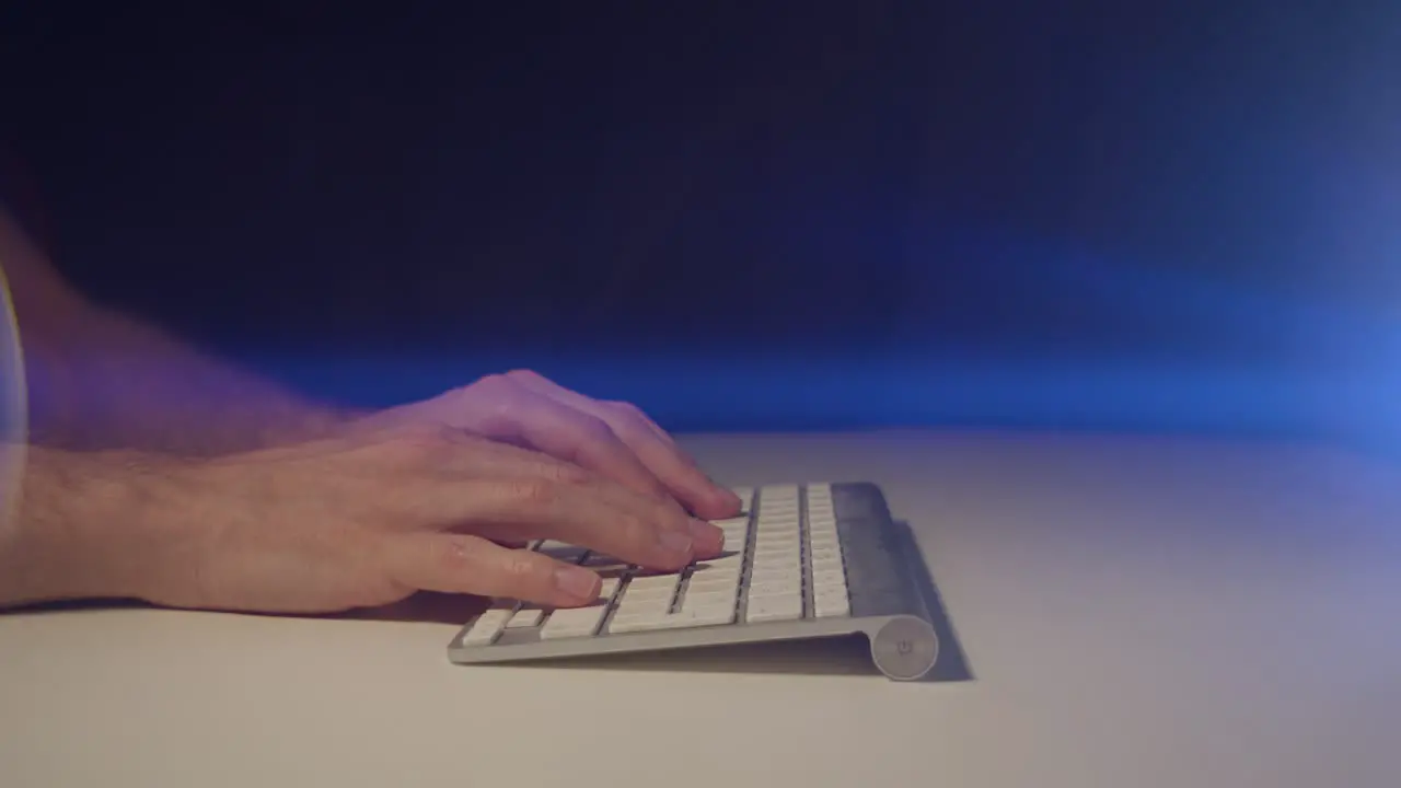 Working from home male hands typing on a keyboard with cinematic lens flare