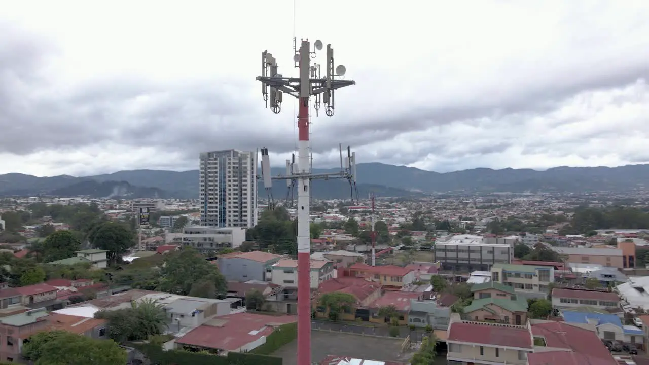 Aerial shot orbiting a cell tower in the city of San Jose Costa Rica