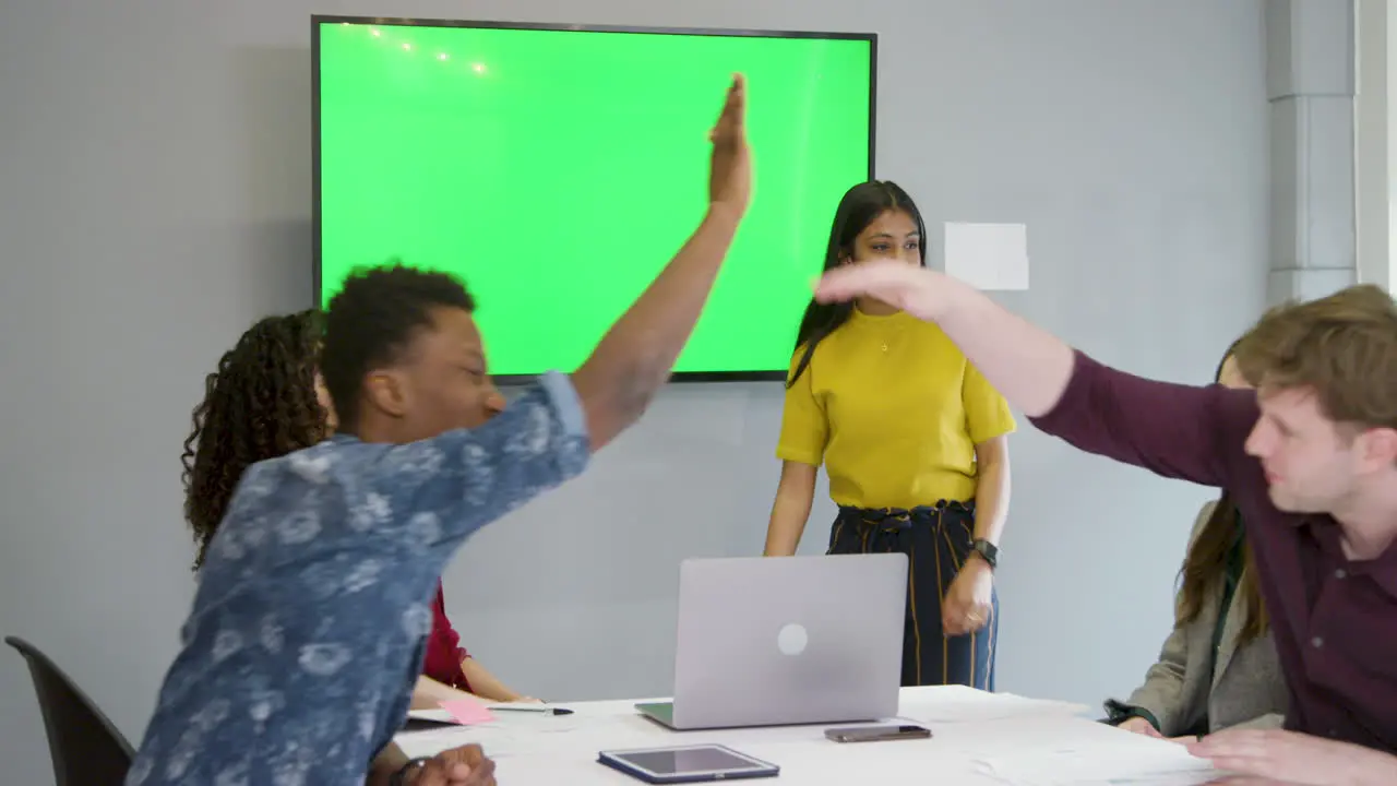 Group Of Colleagues In Meeting High Fiving