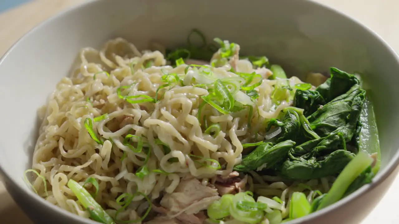 Scallion or green onions drizzled on top of Bakmi wheat based Chinese style noodles