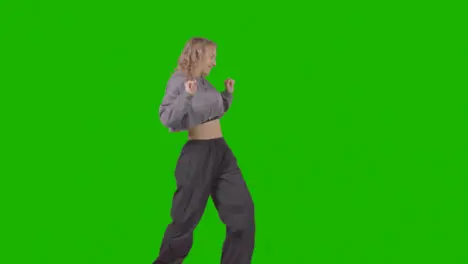 Full Length Studio Shot Of Young Woman Having Fun Dancing Against Green Screen 4