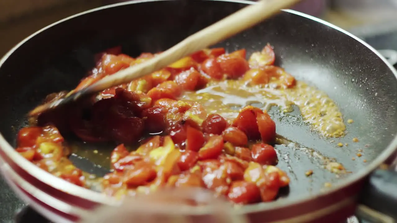 Stirring tomato sauce on pan while cooking