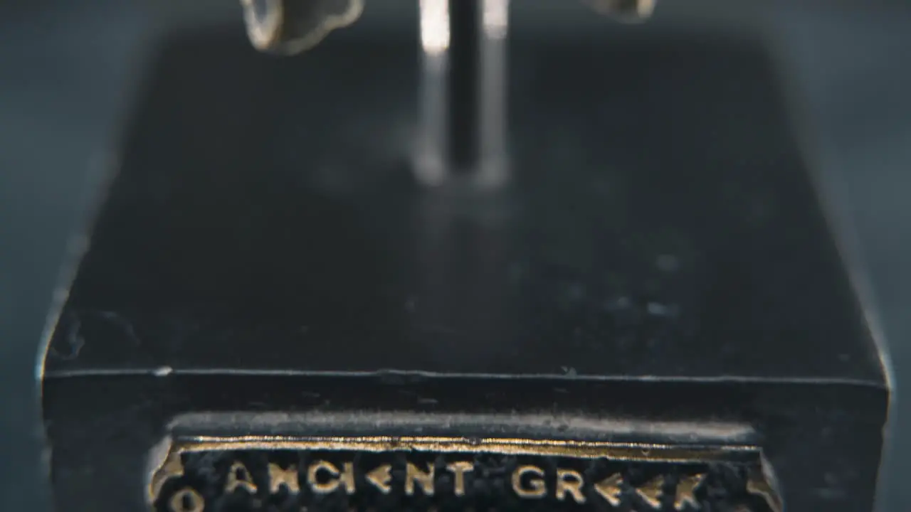 A close up macro detailed slow tilt down shot of a spartan face design warrior ancient greek sign bronze helmet on a 360 rotating stand studio lighting 4K smooth movement