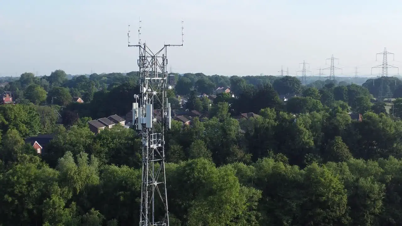 5G broadcasting tower antenna in British countryside with vehicles travelling on highway background aerial left orbit view