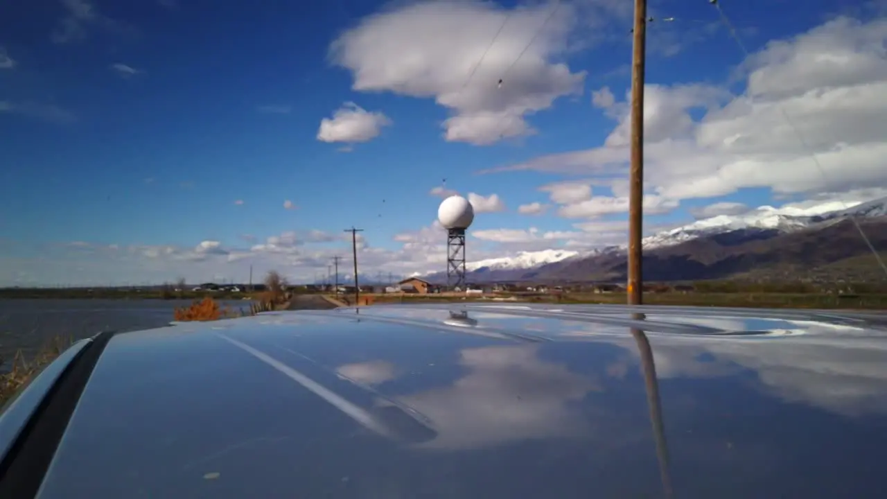 A hyper lapse driving away from a radar tower in the middle of the country