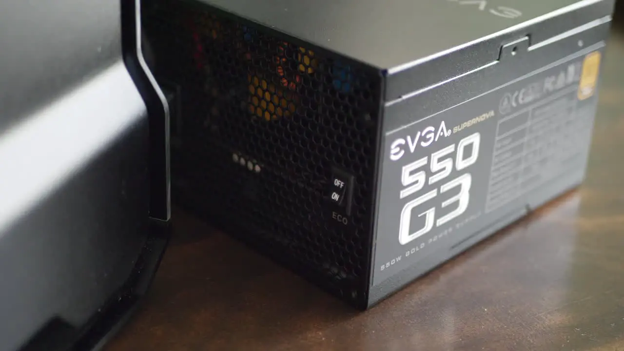 An EVGA Gold rated power supply next to a pc case during a gaming build assembly