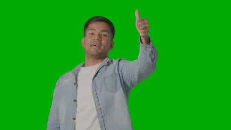 Studio Shot Of Casually Dressed Young Man Giving Thumbs Up Gesture Against Green Screen 2