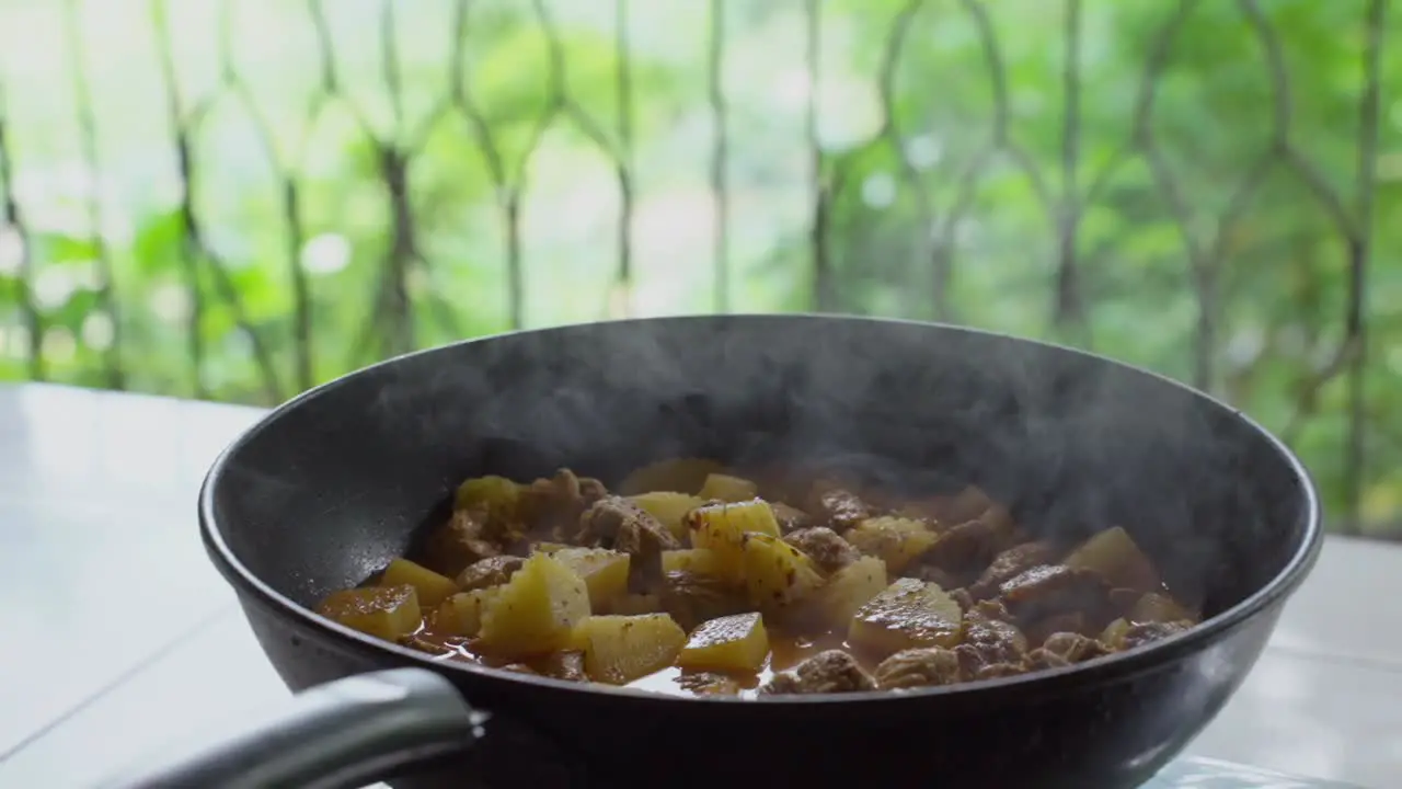 A wok sizzles with steam showcasing a piping hot serving of Massaman curry in a captivating culinary moment