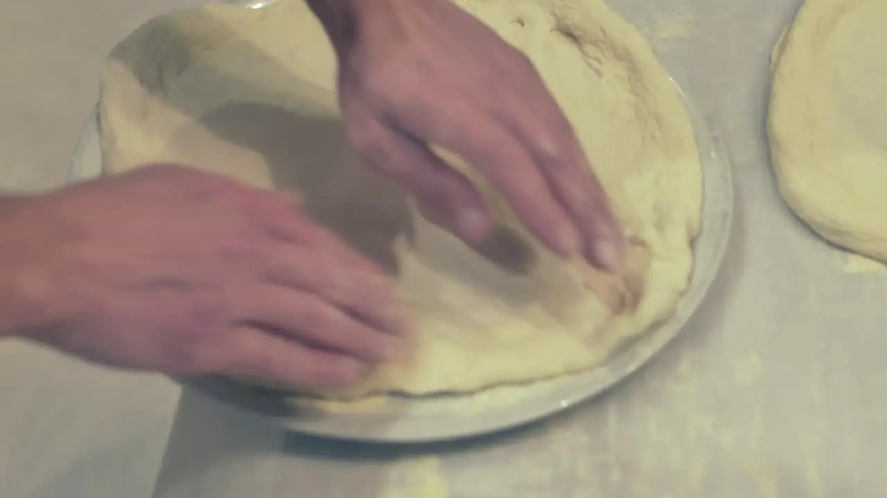 Italian Chef showing how to place the pizza dough on a place before the Pizza dressing