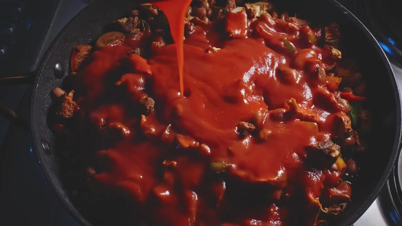 Pouring Red Tomato Sauce Into Spicy Chicken Bean Cooking In A Pan And Stir