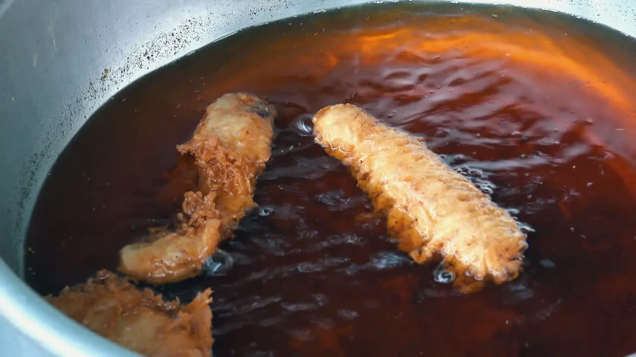 Banana Fritters Frying Away in Dark Oil for Street Food