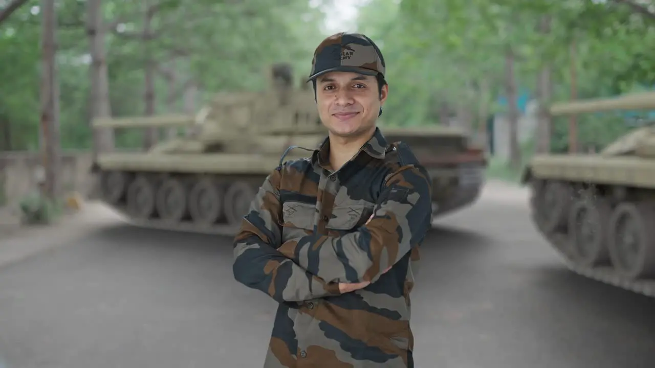 Portrait of happy Indian army man standing crossed hands