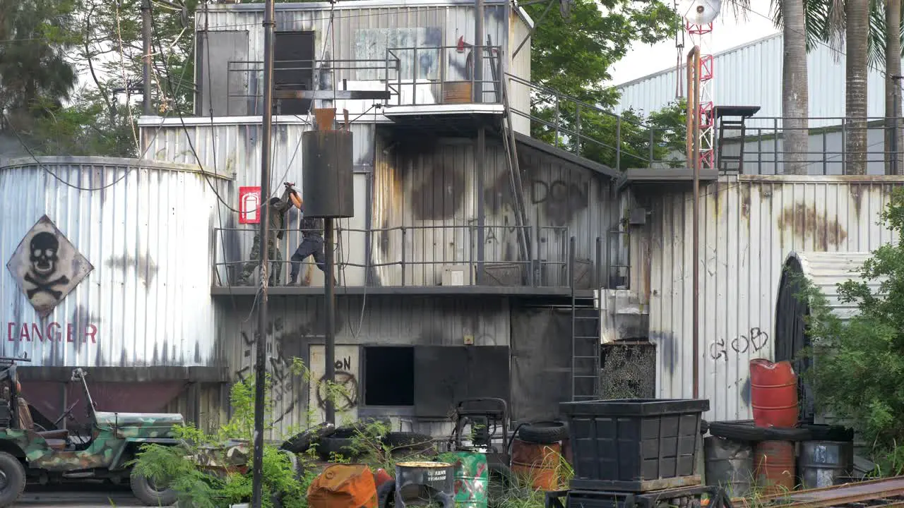 ACTED Policeman fighting versus a criminal with a knife until the criminal falls off of the balcony on industrial terrain