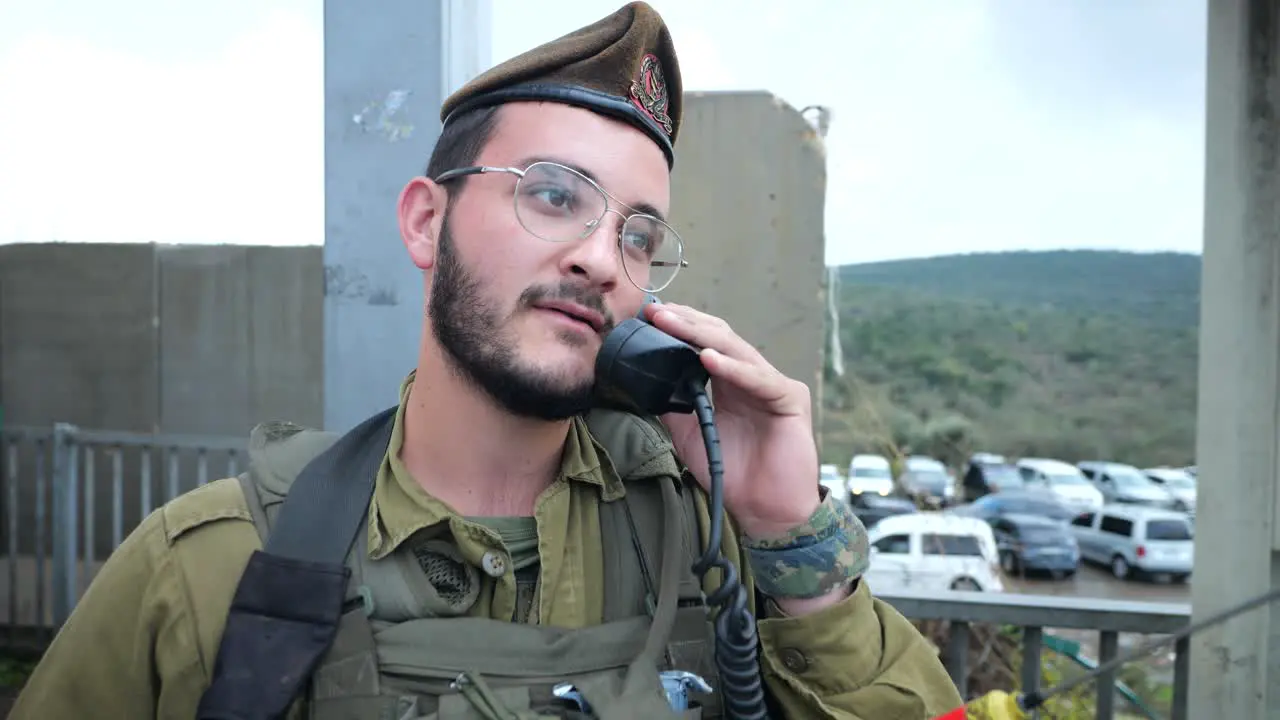 Israeli Army Personnel Man Using Radio Station Transmitter at Checkpoint Sentry Box on Duty Portrait of an Armored Soldier Holding Receiver at Blockroad