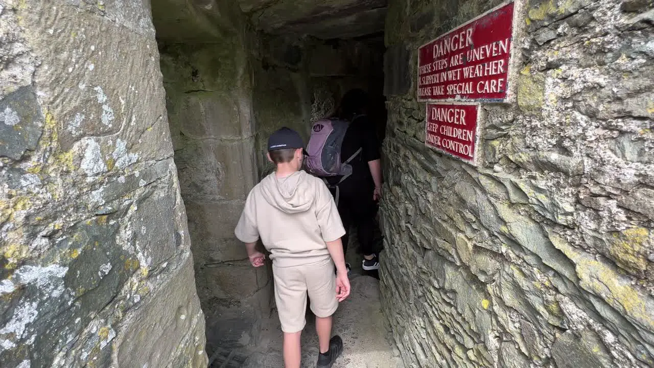 Family descending stone steps at Harlech Castle