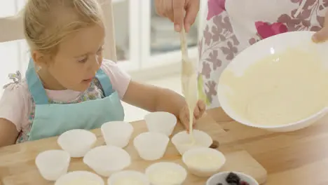 Pouring muffin batter into holders