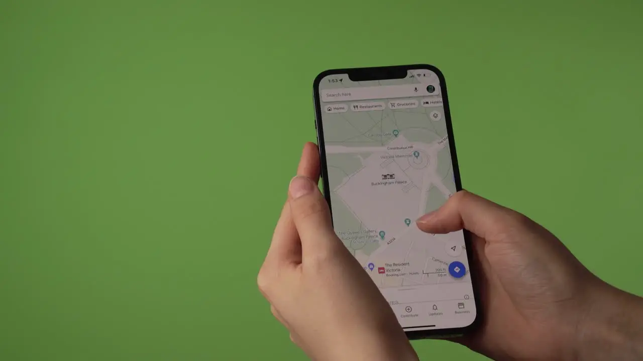 woman looking at Buckingham Palace on google maps in front of greenscreen