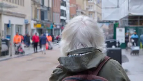 Tracking Shot Following Senior Woman Walking Down Street