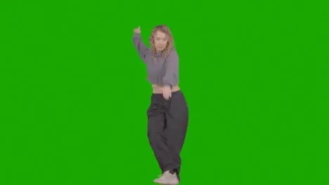 Studio Shot Of Young Woman Having Fun Dancing Against Green Screen 37