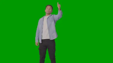 Studio Shot Of Casually Dressed Young Man Giving Thumbs Up Gesture Against Green Screen 4