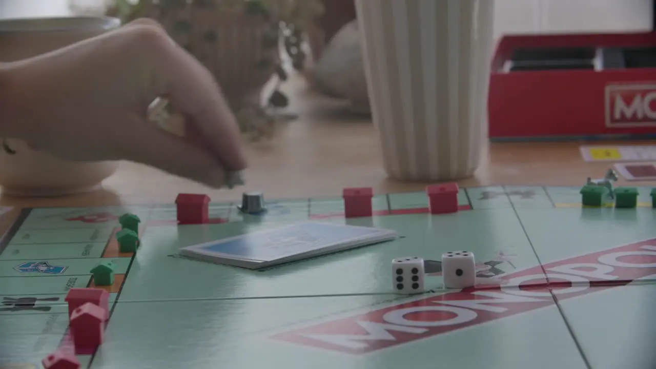 Close up view of a person throwing the dices in a game of Monopoly filmed handheld in 4k