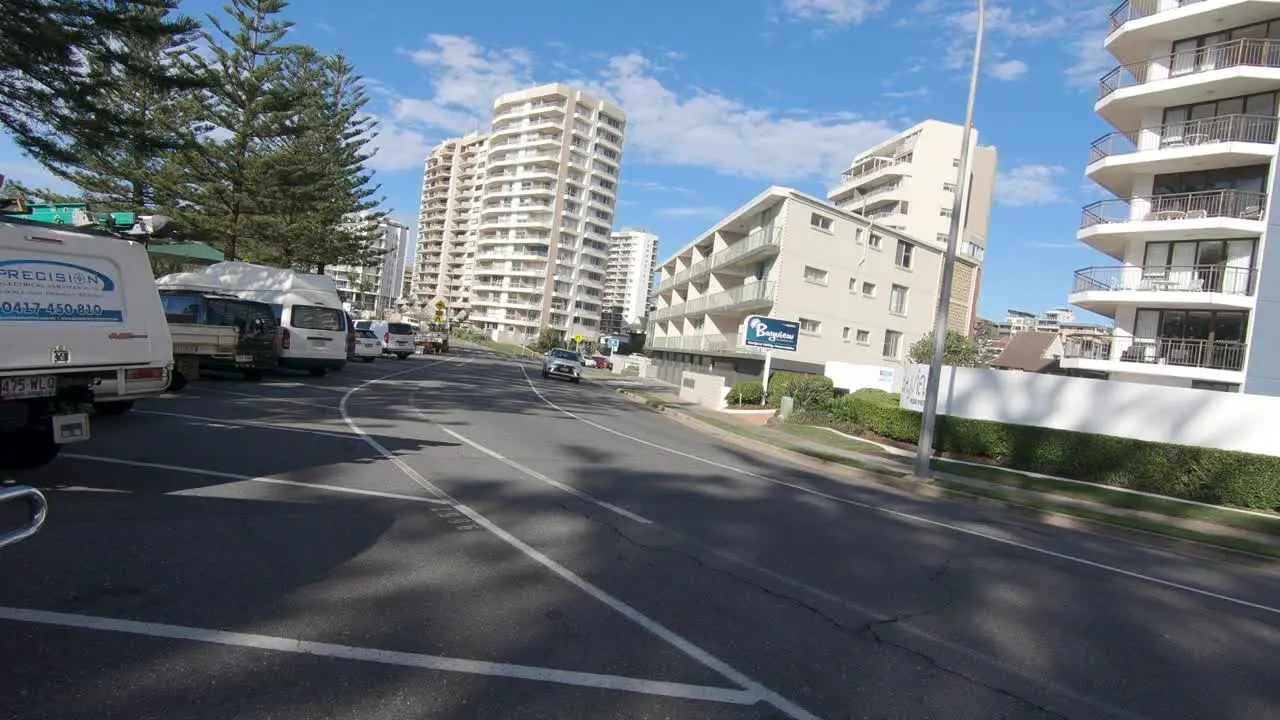 White family car passing by in peaceful neighbourhood with blue sky