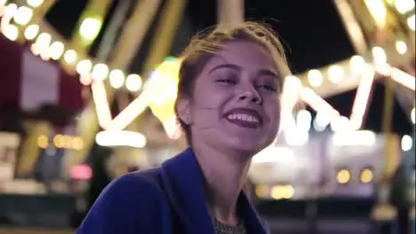 Close Up view of young beautiful happy girl with ponytail smiling and looking at camera hanging out in amusement park with