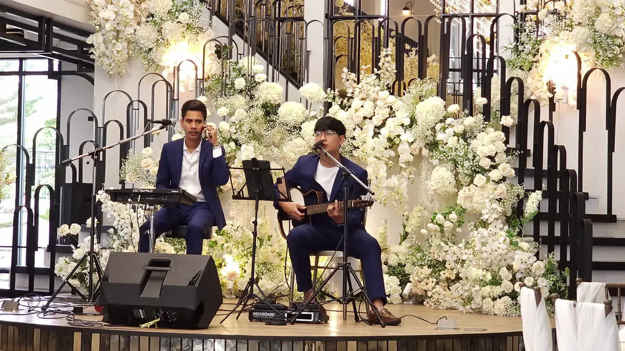 Wedding entertainers a drummer guitarist and vocalists are entertaining guests at a wedding reception in a restaurant in Bangkok Thailand