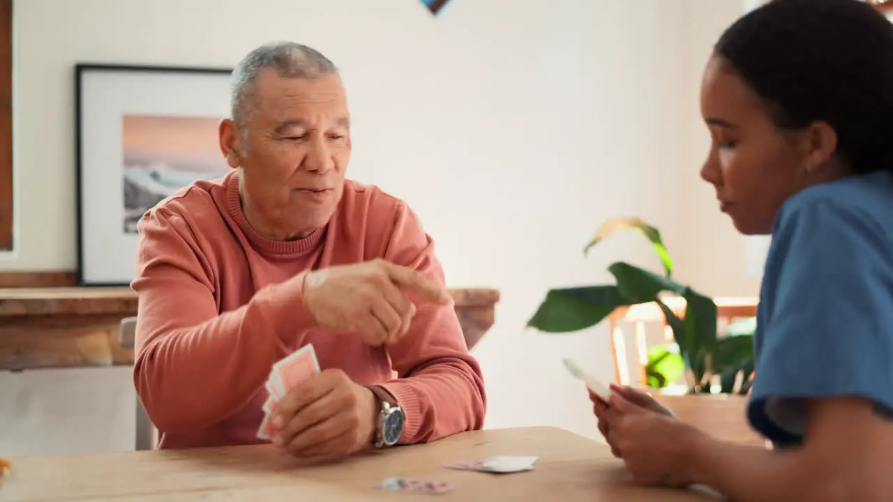 Woman nurse and senior patient playing cards