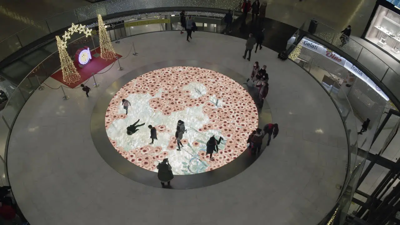 Children having fun on interactive floor screen with flowers in trade centre