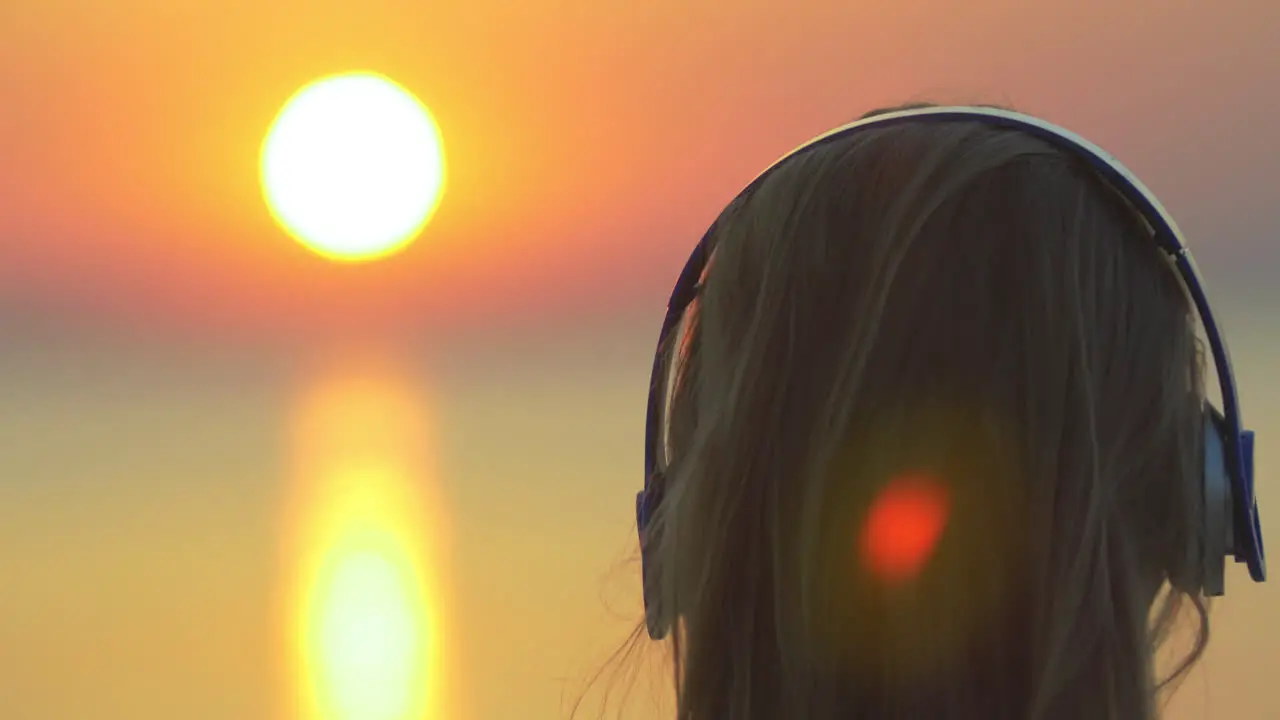 Woman enjoying music and sunset