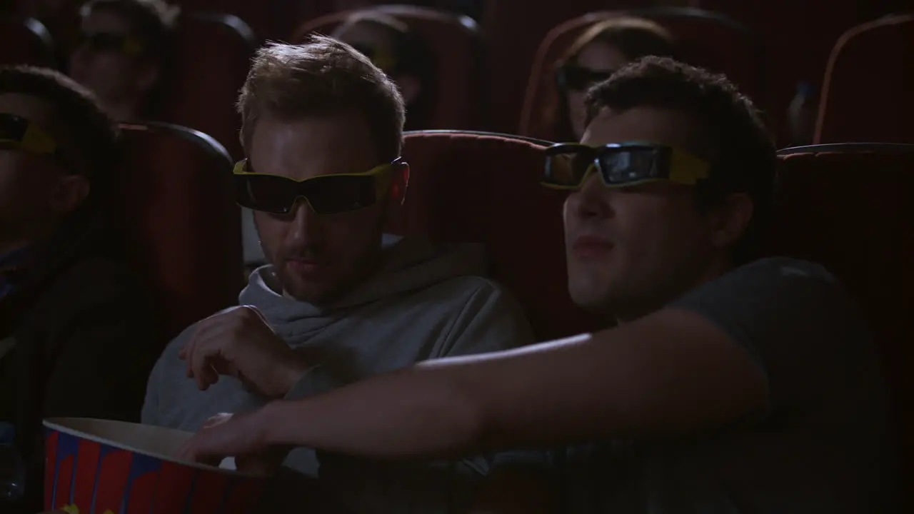 Man eating popcorn in 3d cinema