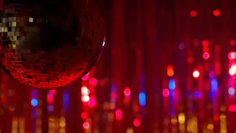 Close Up Of Revolving Mirrorball In Night Club Or Disco With Flashing Strobe Lighting And Sparkling Lights In Background