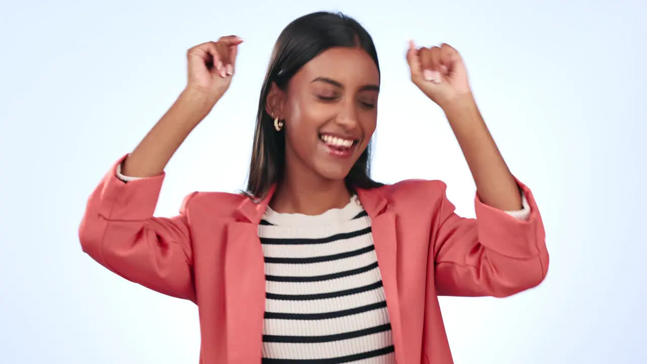 Dancing happy and young woman in a studio