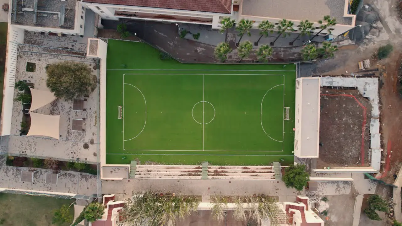 Lowering aerial shot of a soccer pitch in Spain on a warm summer day