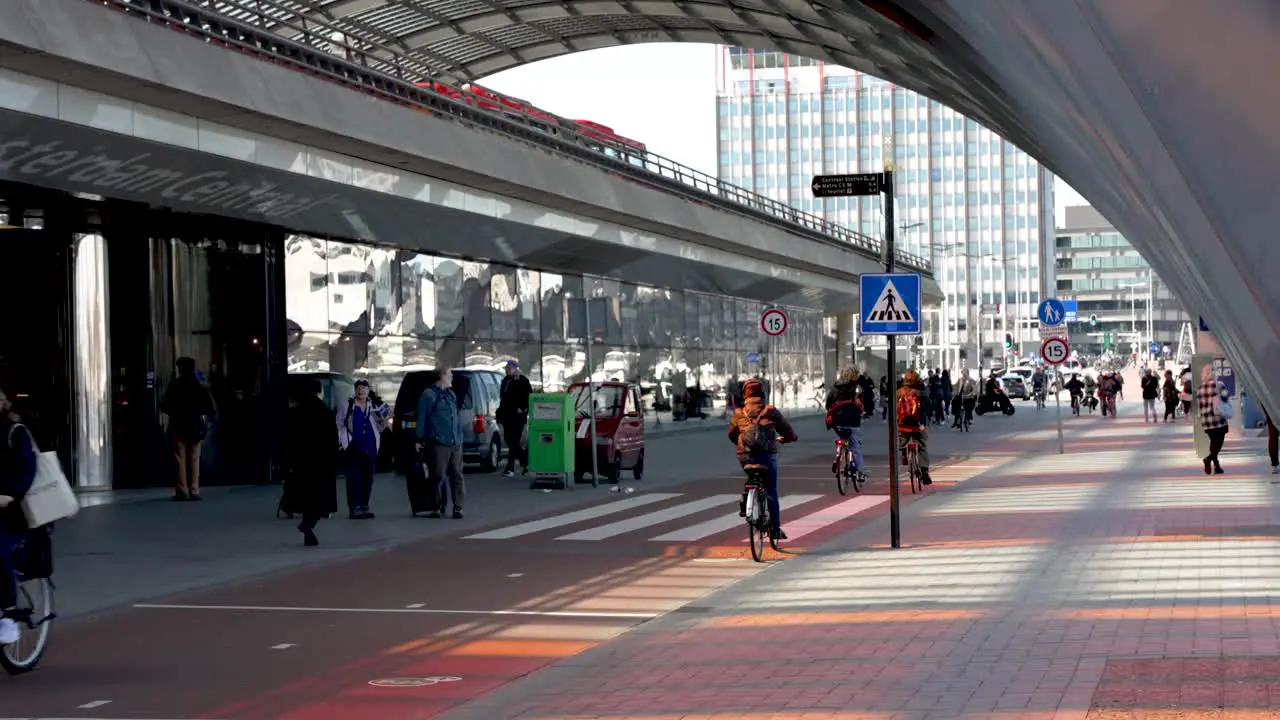 Busy bicycle lane outside of the Amsterdam Central Station as people go about their day commuting on their bicycles in the busy urban city Amsterdam Netherlands