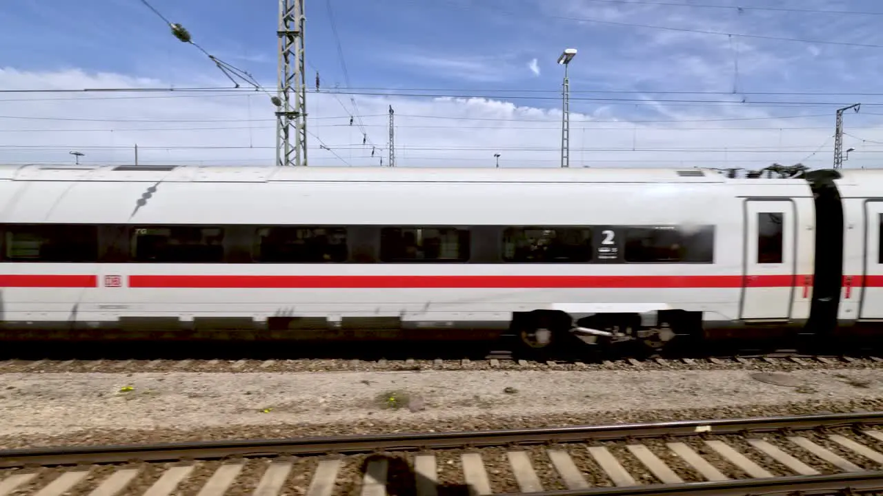 Side POV of german ice train passing empty rail yard