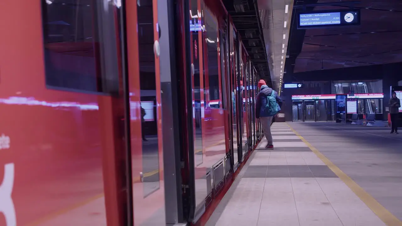 Passengers board subway train at underground station in Helsinki FIN