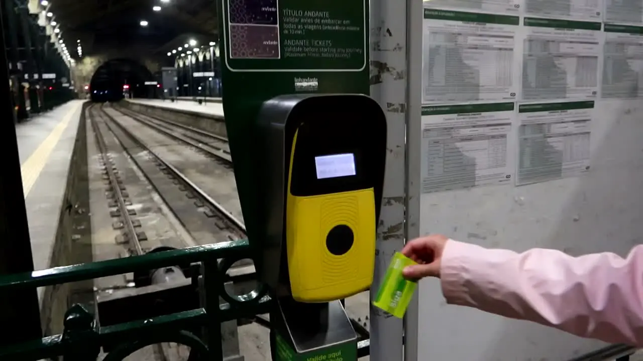 Female hand validates a train ticket at Sao Bento Station in Porto