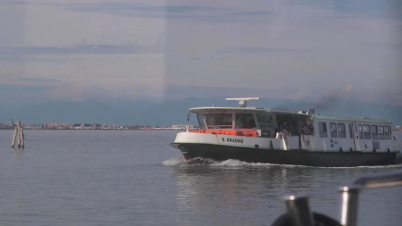 Slow motion shot of ferry carrying passengers passing by off the coast of Venice Italy