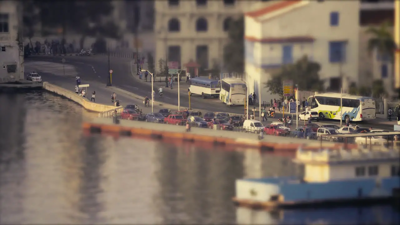 loading and unloading commuters from busses next to a port with boats