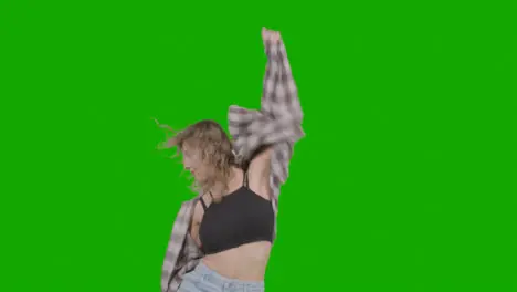 Studio Shot Of Young Woman Having Fun Dancing Against Green Screen