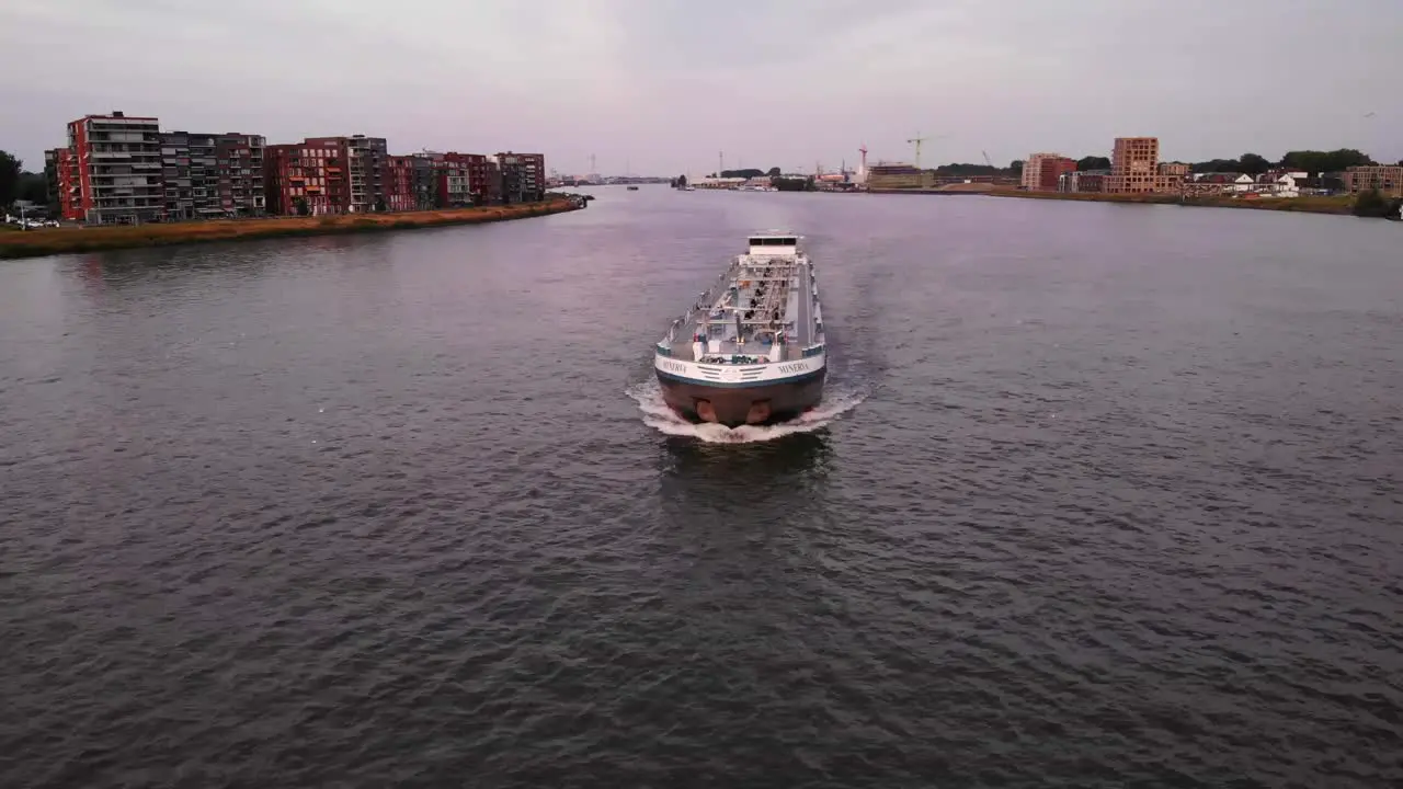 Aerial Front Tracking View of Cargo Tank Barge Waterway Vessel Navigating Along River Canal in Dordrecht Netherlands Nautical Traffic and Coastline Maritime Navigation