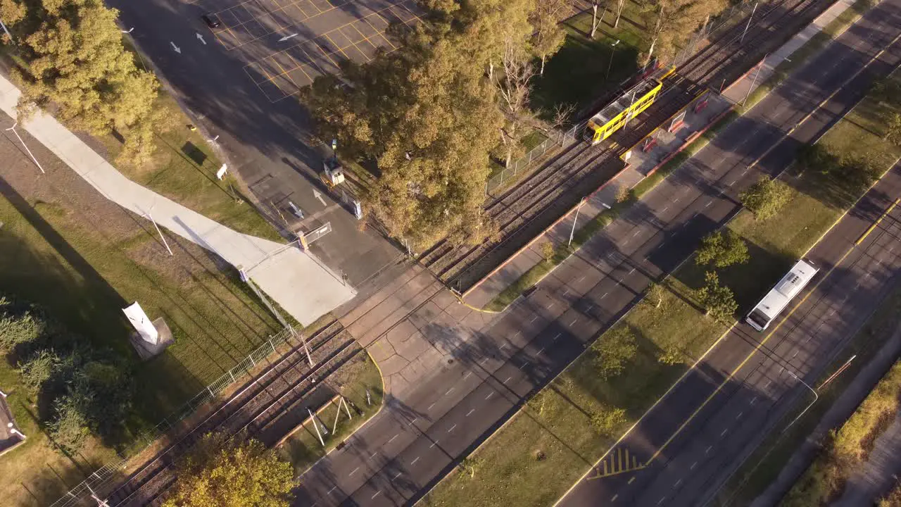 Aerial view orbiting moving yellow streetcar on track