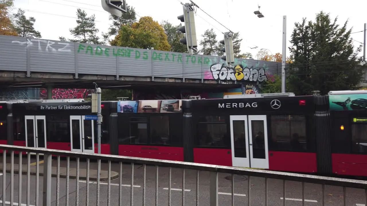 Red Tram Crosses a Bridge with Graffiti in Bumpliz Neighborhood Bern Switzerland