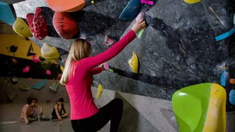 Teenage girl bouldering indoors