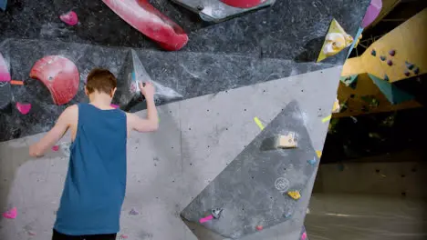 Boy bouldering in a gym