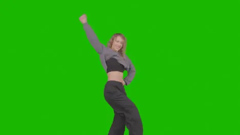 Studio Shot Of Young Woman Having Fun Dancing Against Green Screen 27